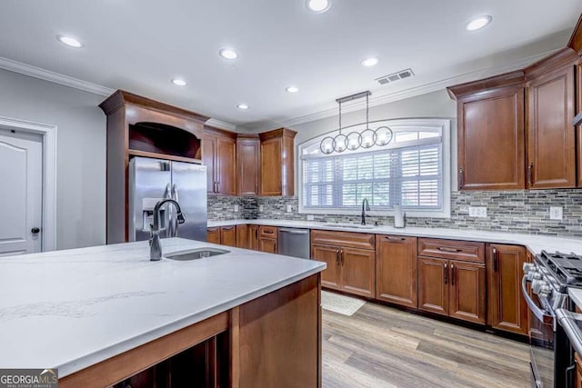 kitchen featuring crown molding, light wood-type flooring, stainless steel appliances, sink, and tasteful backsplash