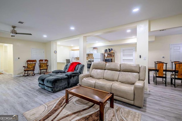 living room featuring light hardwood / wood-style flooring and ceiling fan