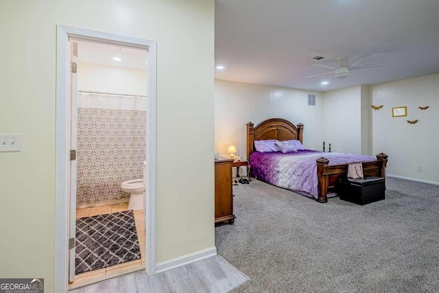 carpeted bedroom featuring ensuite bath and ceiling fan