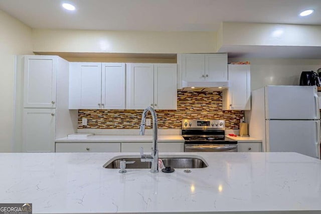 kitchen with white fridge, stainless steel electric stove, sink, light stone counters, and white cabinets