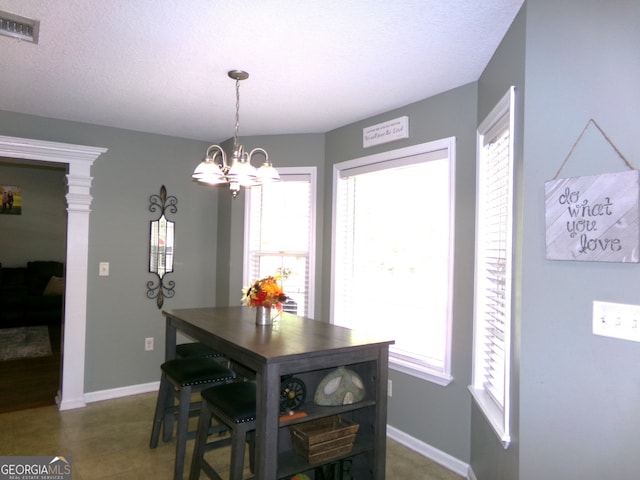 dining room with a textured ceiling and an inviting chandelier