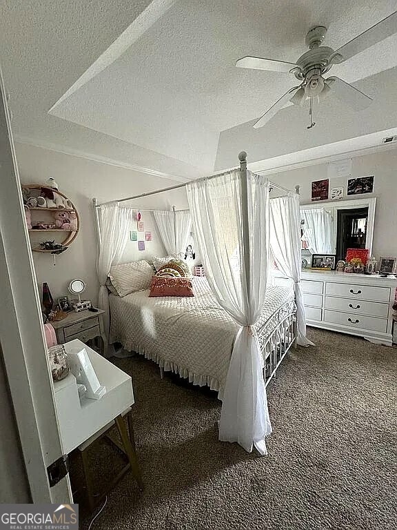 bedroom featuring a textured ceiling, ceiling fan, and carpet floors