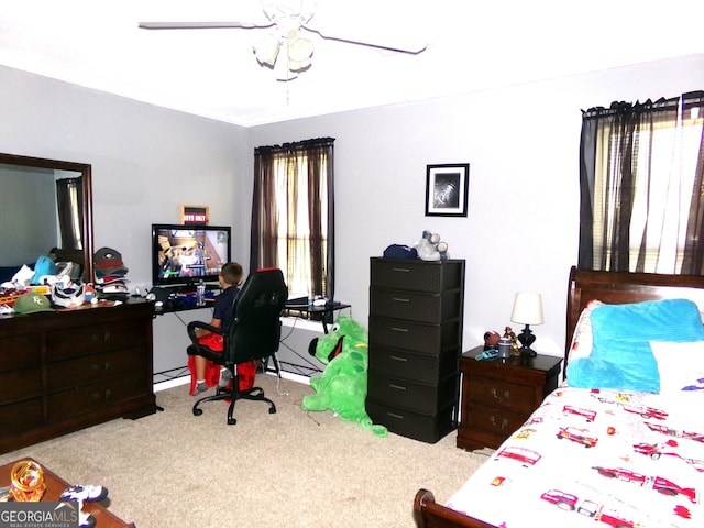 carpeted bedroom with ceiling fan and multiple windows