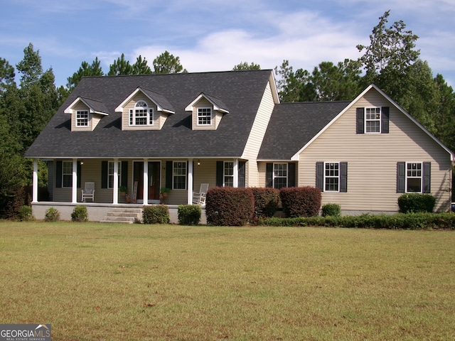 cape cod house featuring covered porch and a front lawn