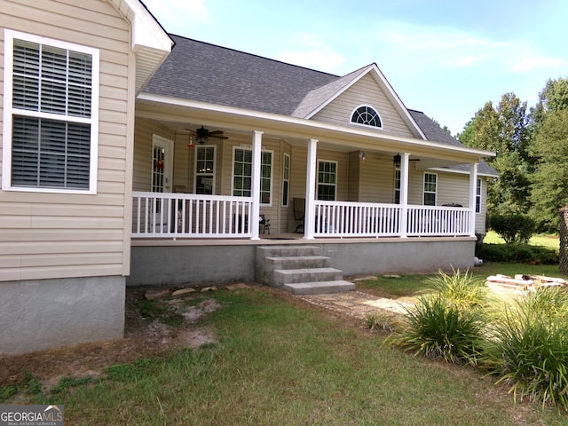 view of front of property with a front yard, a porch, and ceiling fan