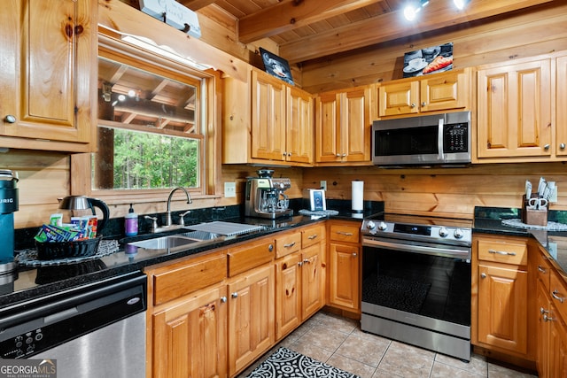 kitchen with light tile patterned floors, beam ceiling, wood ceiling, stainless steel appliances, and sink