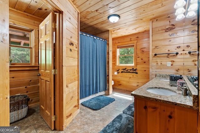 bathroom with toilet, wooden walls, wooden ceiling, and vanity