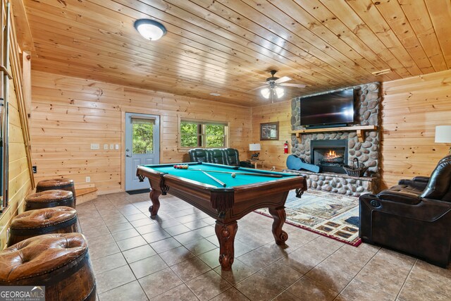 rec room with a fireplace, wood walls, ceiling fan, and pool table