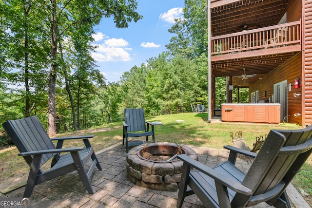 view of patio / terrace featuring ceiling fan, an outdoor fire pit, and a hot tub