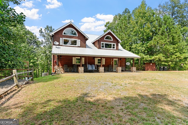 view of front of house featuring a storage shed, a front yard, and a porch