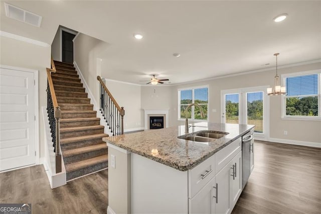 kitchen featuring a kitchen island with sink, white cabinetry, dark hardwood / wood-style flooring, and sink