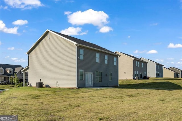 back of property with a lawn and central air condition unit