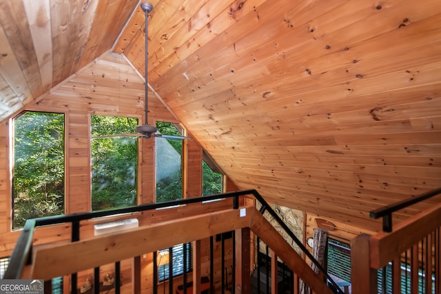 interior space featuring wood ceiling, wood walls, and ceiling fan