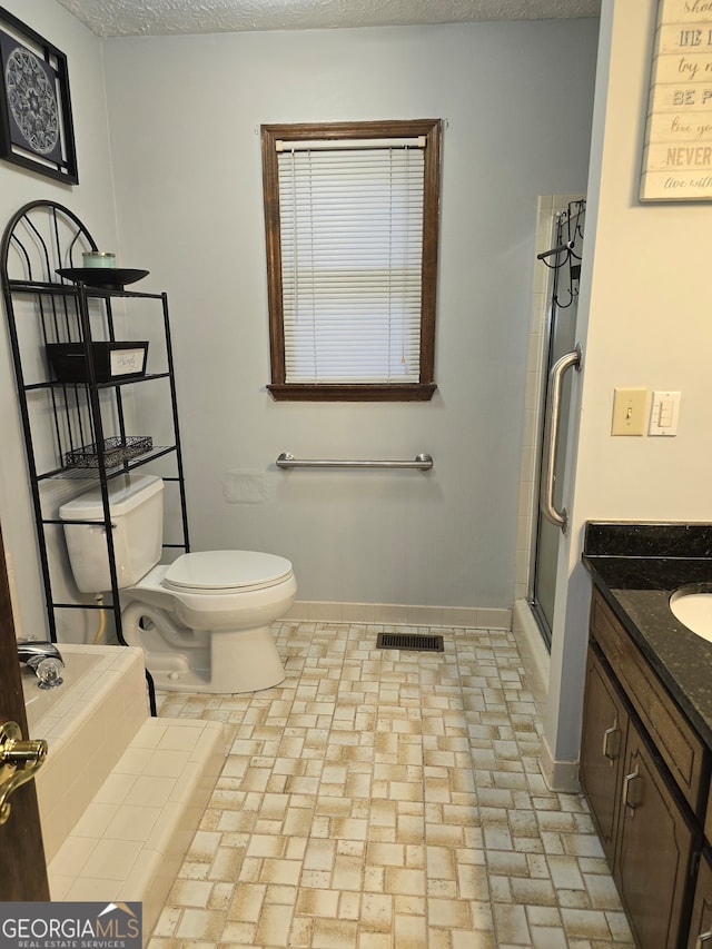 bathroom with a textured ceiling, vanity, toilet, and an enclosed shower