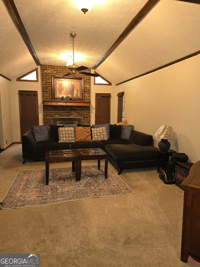 living room with carpet floors, vaulted ceiling with beams, a textured ceiling, and a fireplace