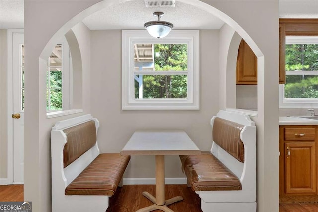 dining area with breakfast area, a textured ceiling, and wood-type flooring