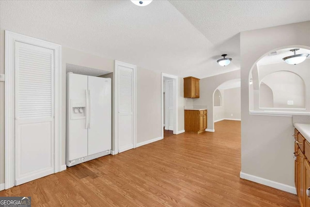 interior space featuring light wood-type flooring and a textured ceiling