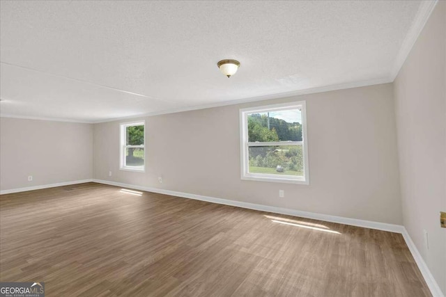 unfurnished room with hardwood / wood-style flooring, a textured ceiling, and a healthy amount of sunlight