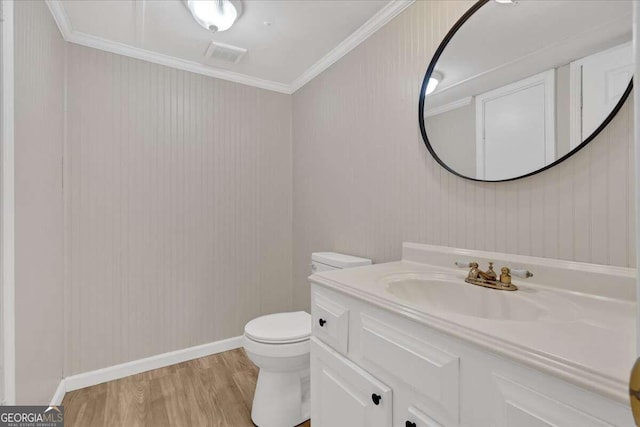 bathroom featuring vanity, toilet, ornamental molding, and wood-type flooring