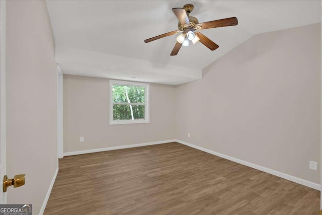 empty room with wood-type flooring, vaulted ceiling, and ceiling fan