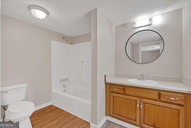 full bathroom with shower / tub combination, toilet, wood-type flooring, vanity, and a textured ceiling