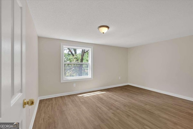 unfurnished room featuring hardwood / wood-style floors and a textured ceiling