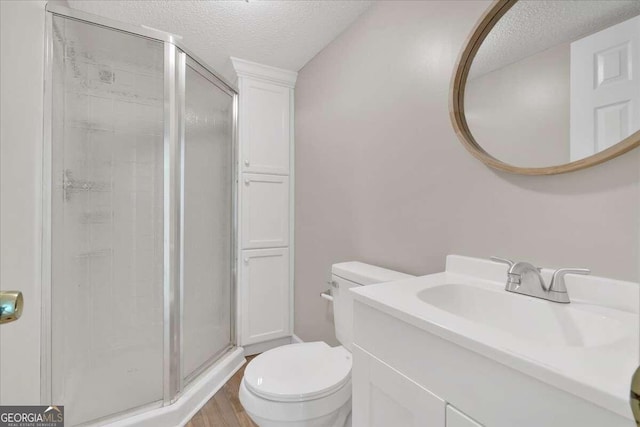 bathroom featuring an enclosed shower, toilet, wood-type flooring, vanity, and a textured ceiling