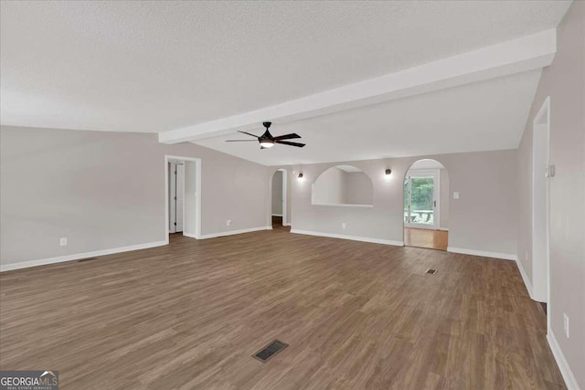 interior space featuring a textured ceiling, wood-type flooring, ceiling fan, and vaulted ceiling with beams