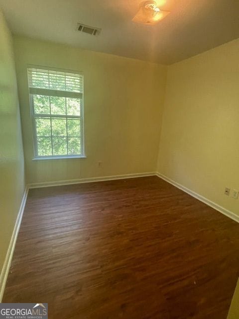 spare room with dark wood-type flooring