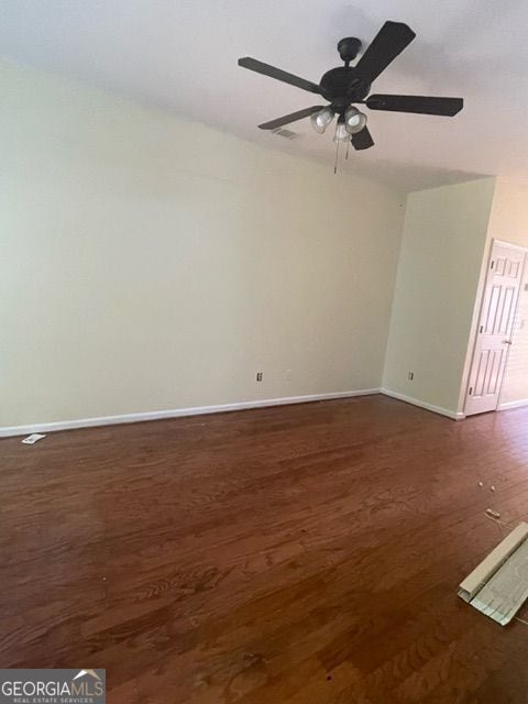 empty room featuring dark wood-type flooring and ceiling fan