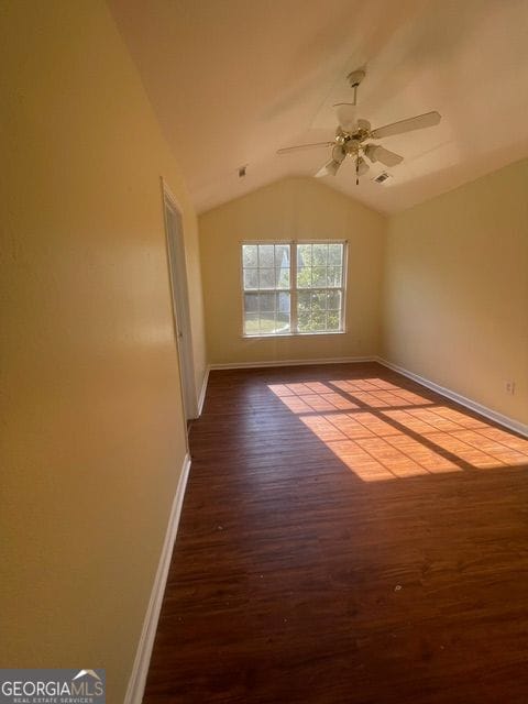 empty room featuring lofted ceiling, ceiling fan, and dark hardwood / wood-style flooring