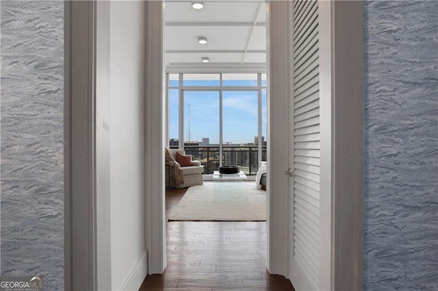 corridor with floor to ceiling windows and dark hardwood / wood-style floors