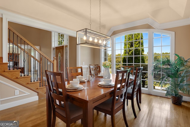 dining space featuring crown molding, an inviting chandelier, and light wood-type flooring