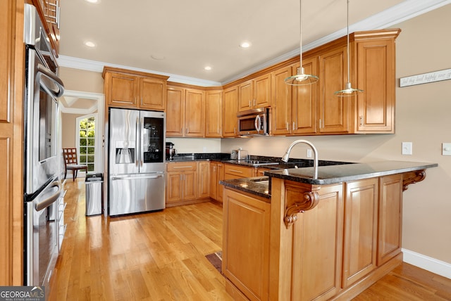 kitchen featuring pendant lighting, appliances with stainless steel finishes, light hardwood / wood-style floors, kitchen peninsula, and dark stone counters