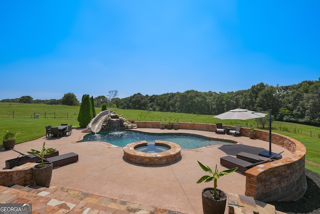 view of pool with a patio area, an in ground hot tub, a yard, and a water slide