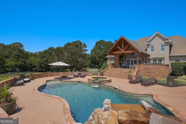 view of swimming pool with an in ground hot tub, pool water feature, and a patio