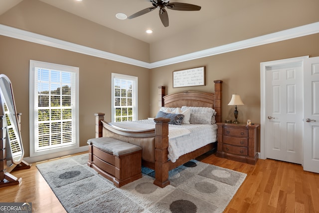 bedroom featuring multiple windows, ceiling fan, light hardwood / wood-style floors, and ornamental molding