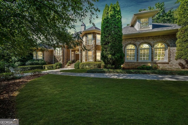 view of front of house featuring brick siding and a front lawn