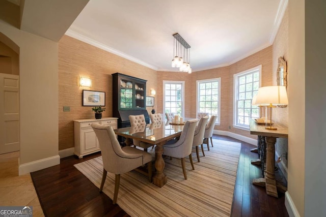 dining area with crown molding, hardwood / wood-style floors, and a notable chandelier