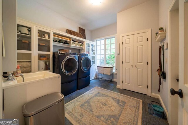 washroom with washing machine and dryer and dark tile patterned floors