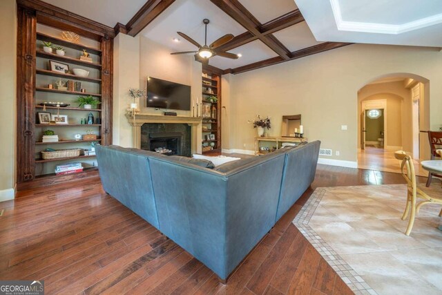 living room with hardwood / wood-style floors, ceiling fan, beamed ceiling, and a premium fireplace