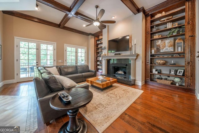 living room with built in shelves, ceiling fan, dark hardwood / wood-style floors, and coffered ceiling