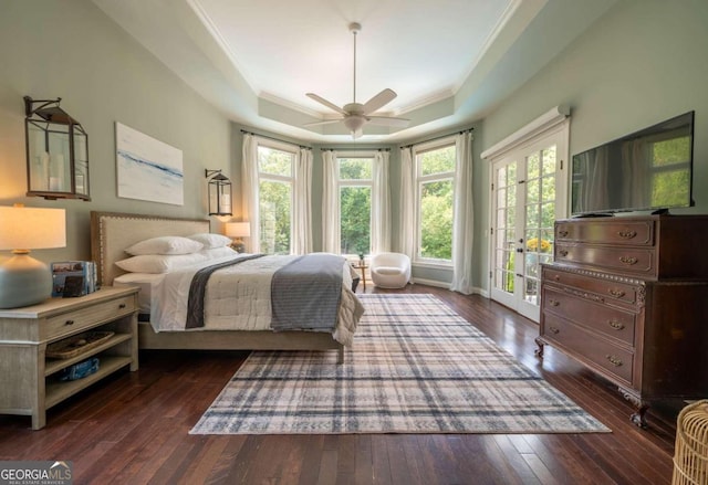 bedroom with a tray ceiling, french doors, access to outside, and dark hardwood / wood-style floors