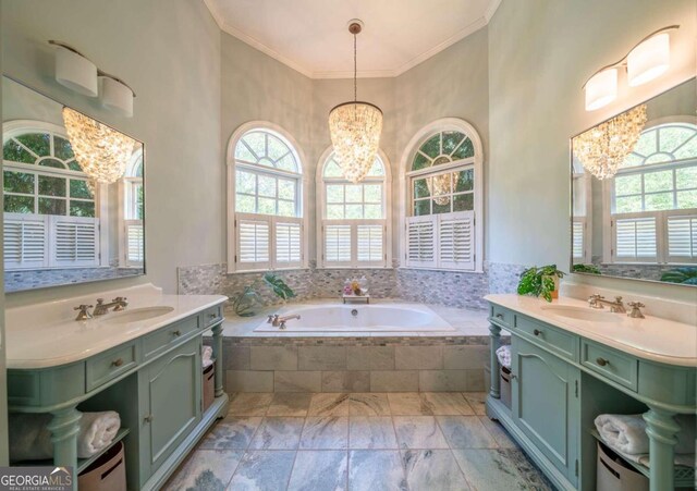 bathroom with ornamental molding, vanity, a notable chandelier, and tiled bath