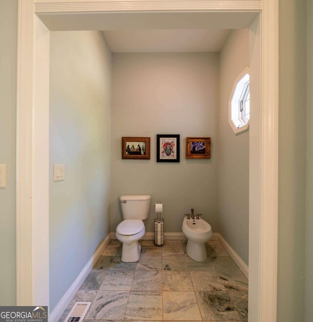 bathroom featuring a bidet, toilet, and tile patterned flooring