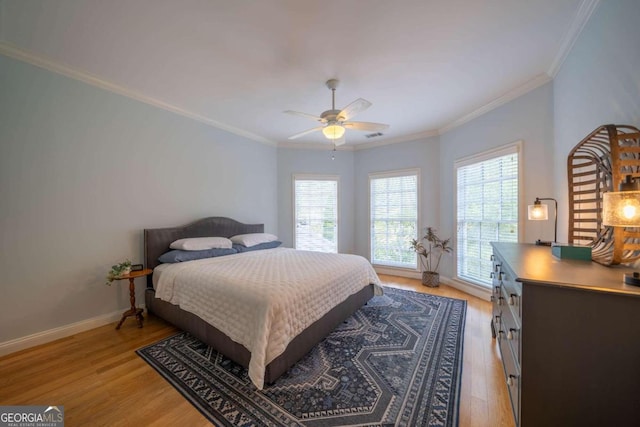 bedroom with ceiling fan, ornamental molding, and light hardwood / wood-style flooring