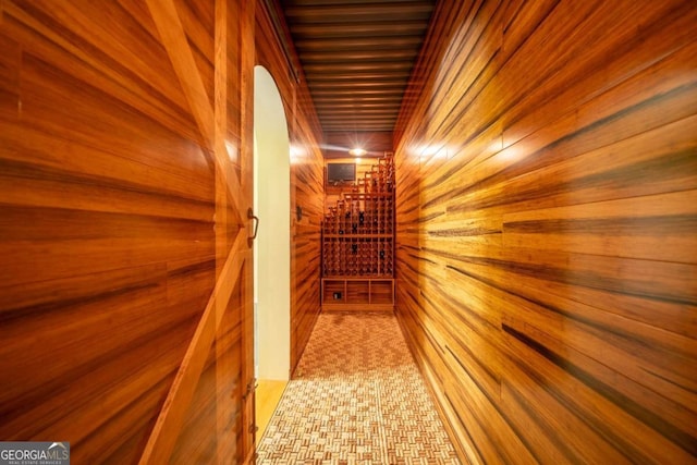 corridor featuring wooden walls