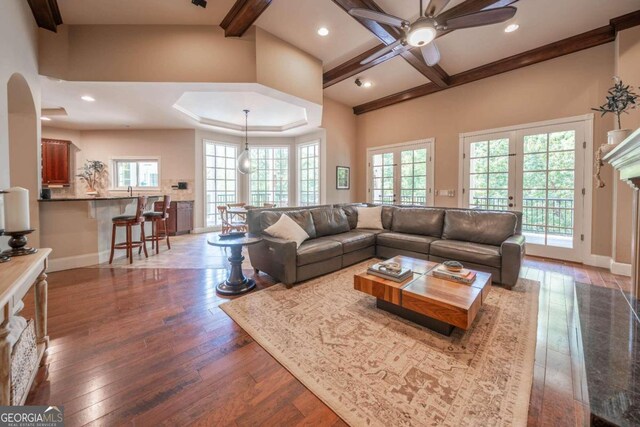 living room featuring ceiling fan, hardwood / wood-style flooring, and beam ceiling