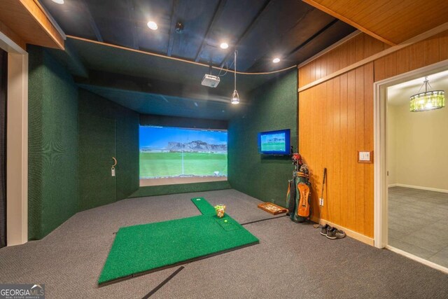 rec room with carpet, wood walls, and golf simulator