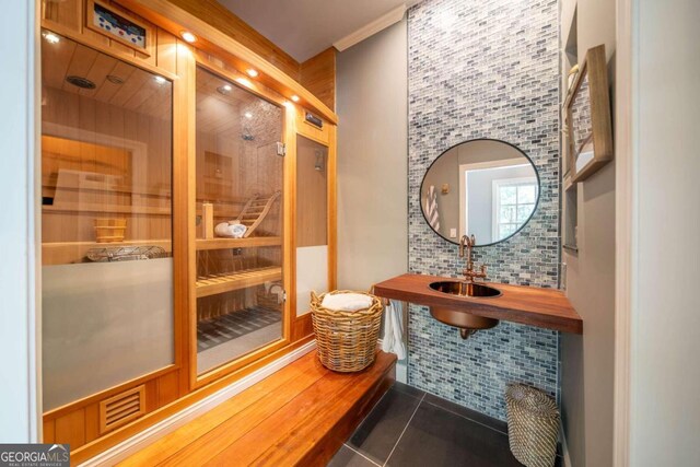 bathroom featuring tile patterned floors, tasteful backsplash, and sink